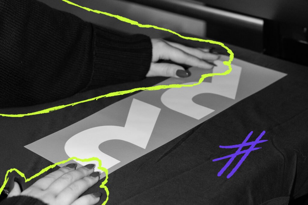 Hände platzieren einen Schriftzug auf einem Textil bei der Textilveredelung